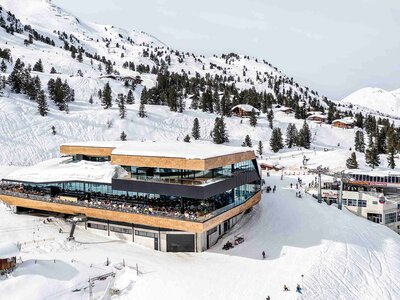 Bergstation einer Gondelbahn umgeben von einer winterlichen Berglandschaft