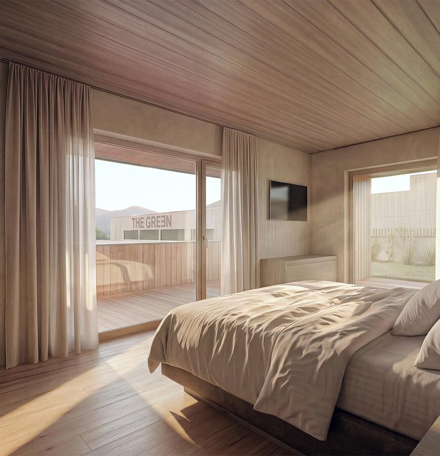 thegreen-zimmer-haupthaus-1 Schlafzimmer mit großem Bett, Holzwänden und -boden, Zugang zu Balkon mit Sitzmöbeln